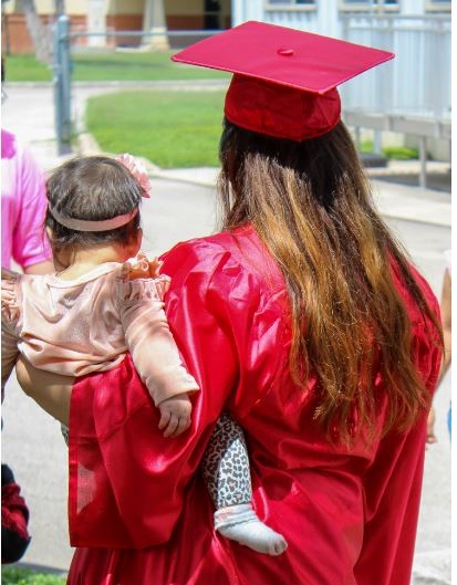 mother in graduation gown with child